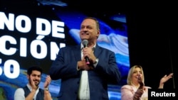 National Party presidential candidate Alvaro Delgado addresses supporters with his running mate Valeria Ripoll and Colorado Party presidential candidate Andres Ojeda following the first exit polls during the general election, in Montevideo, Uruguay October 27, 2024.