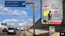 FILE - Billboards from Hezbollah's committee for the support of the Islamic resistance that shows a Hezbollah fighter while holding the group's yellow banner and Lebanon's national flag, are displayed on a highway in southern Beirut, Lebanon, Jan. 19, 2018.