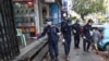 Members of Yangon City and Development Committee spray disinfectant along a sidewalk in hopes of curbing the spread of the new coronavirus, Myanmar, March 29, 2020. 