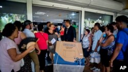 Un trabajador de una tienda que comercializa en divisas retira un equipo electrodoméstico recién comprado, en La Habana, Cuba. [Foto: Archivo]