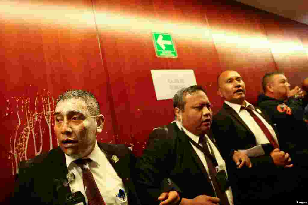 Senate security personnel lock their arms to try to prevent demonstrators from entering a Senate session room as a highly contested judicial reform proposal is debated in Mexico City, Mexico, Sept. 10, 2024. 