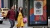 FILE - A couple walks next to a sign announcing the COP16 summit in Cali, Valle del Cauca province, Colombia, on July 22, 2024.