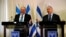 Avigdor Lieberman, head of the Yisrael Beitenu party, left, and Israeli Prime Minister Benjamin Netanyahu talk to reporters after signing a coalition deal to broaden the government's parliamentary majority at the Knesset in Jerusalem, May 25, 2016. 