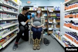 FILE - Michelle Melton, who is 35 weeks pregnant, receives the Pfizer-BioNTech vaccine against COVID-19 at Skippack Pharmacy in Schwenksville, Pa., Feb. 11, 2021.