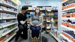 FILE - Michelle Melton, who is 35 weeks pregnant, receives the Pfizer-BioNTech vaccine against the coronavirus disease (COVID-19) at Skippack Pharmacy in Schwenksville, Pennsylvania, U.S., Feb. 11, 2021.