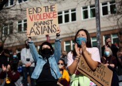 FILE - Demonstrators cheer while listening to speakers during a protest against anti-Asian hate crimes at Hing Hay Park in the Chinatown-International District of Seattle, Washington, March 13, 2021.