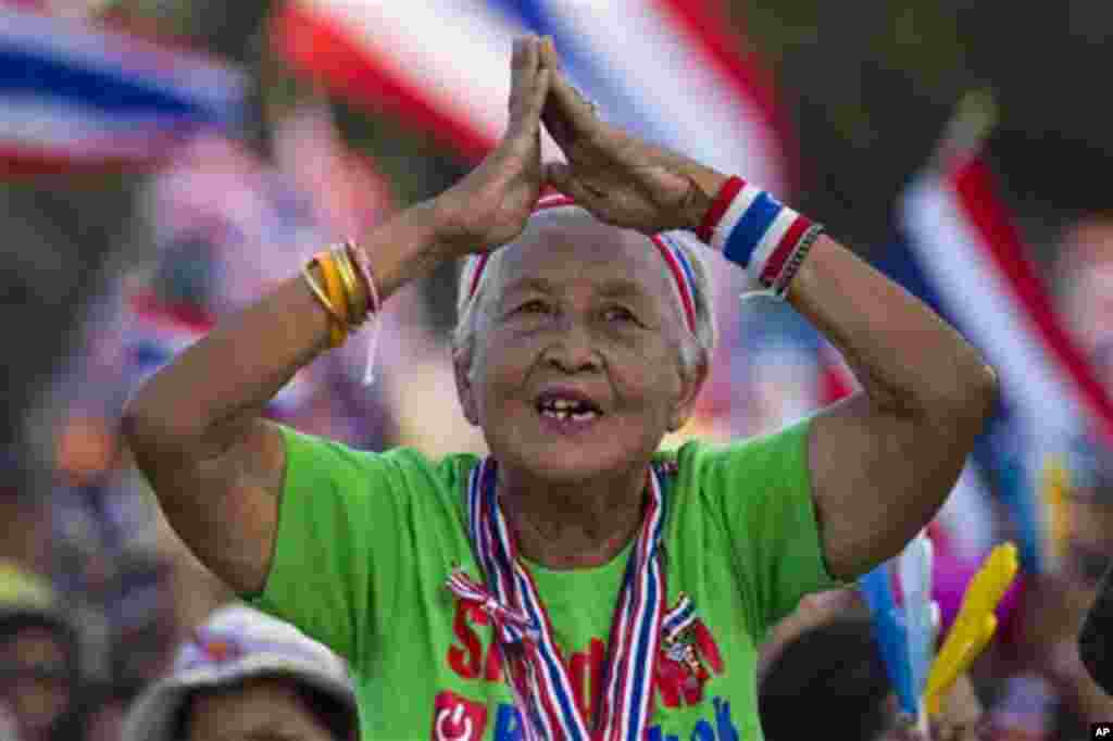 A Thai anti-government protester gestures while listening to a speech from the stage during a rally at the Democracy Monument in Bangkok, Sunday, Jan. 12, 2014. Anti-government demonstrators were preparing Sunday to occupy major intersections of Thailand'
