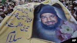 Kelompok Islam garis keras Pakistan membawa poster Mumtaz Qadri dalam unjuk rasa di Karachi untuk menentang hukuman mati yang dijatuhkan oleh pengadilan Pakistan (foto: dok).