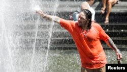 A man enjoys a cooling spray from a fountain during a heat wave in Manhattan, New York, July 23, 2016.