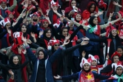 FILE -- Female Iranian spectators clap as they wait to start a soccer match between Iran's Persepolis and Japan's Kashima Antlers during the 2nd leg of the Asian Champions League finals at the Azadi (freedom) stadium in Tehran, Iran, Nov. 10, 2018.