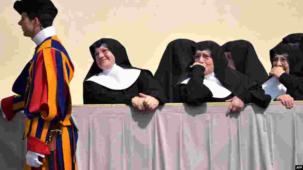 Des religieuses, debout, à la place Saint-Pierre au Vatican à la fin de l'audience générale hebdomadaire du pape le 2 Avril 2014.