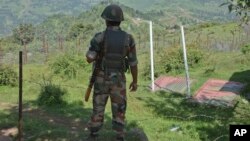 FILE- Indian army soldier guards near fence on the line of control near Balakot sector in Poonch, Jammu and Kashmir, India, Aug.17, 2015. 