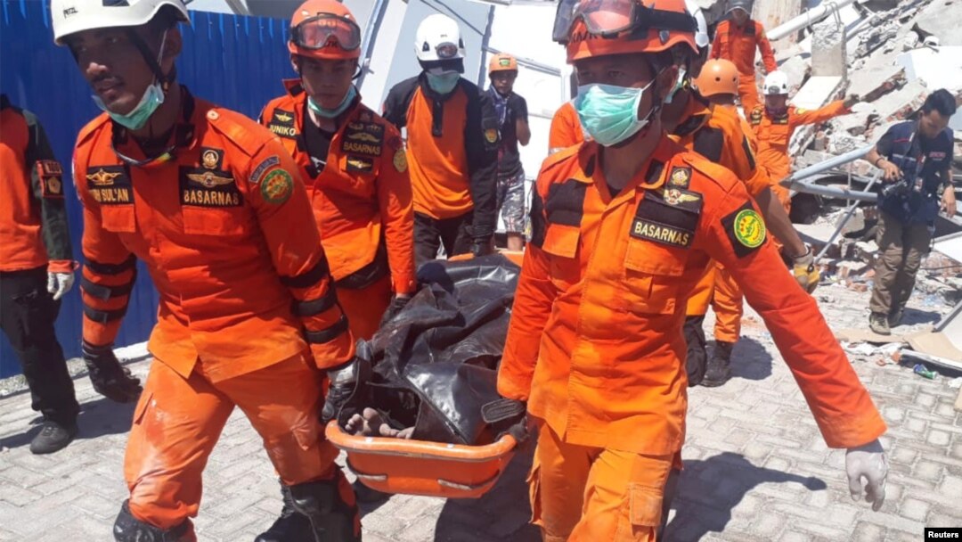 Tim SAR membawa korban dari reruntuhan Hotel Roa-Roa di Palu, Sulawesi Tengah, 30 September 2018.