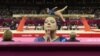 Ethiene Cristina Gonser Franco of Brazil (C) prays whilst teammate Harumy Mariko de Freitas performs on the balance beam during the women's gymnastics qualification at the North Greenwich Arena during the London 2012 Olympic Games July 29, 2012. 