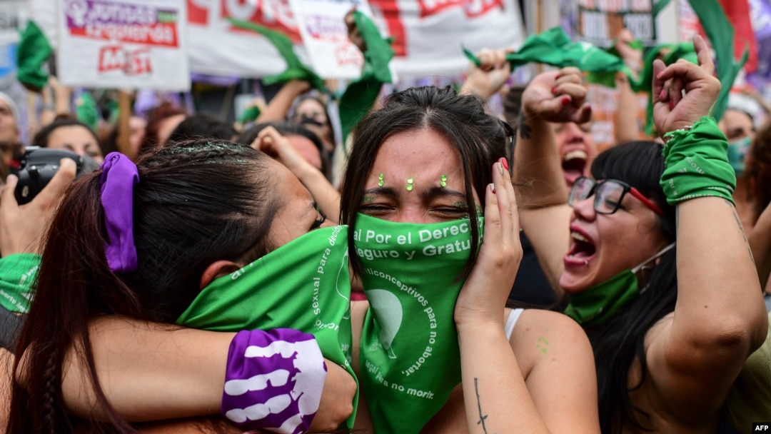 Para pengunjuk rasa pro-aborsi mengenaka kain hijau merayakan pengesahan undang-undang yang melegalkan aborsi di luar Kongres Argentina, di Buenos Aires, 30 Desember 2021. 