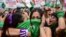 Demonstrators celebrate with green headscarves - the symbol of abortion rights activists - outside the Argentine Congress in Buenos Aires on December 11, 2020, after legislators passed a bill to legalize abortion.