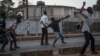 Supporters of the opposition Sierra Leone People's Party throw rocks at police following an alleged incident at party headquarters in Freetown's Goderich neighborhood, March 7, 2018. (J. Patinkin/VOA)