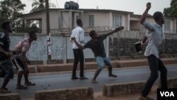 Supporters of the opposition Sierra Leone People's Party throw rocks at police following an alleged incident at party headquarters in Freetown's Goderich neighborhood, March 7, 2018. (J. Patinkin/VOA)