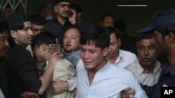 People comfort youths who lost their family members in a shooting in Quetta, Pakistan on Sept 20, 2011.