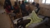 A man who has waited for surgery for a week lies with his family around him at Juba Teaching Hospital, South Sudan's largest medical facility, May 23, 2016. (J. Patinkin/VOA)