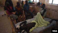 A man who has waited for surgery for a week lies with his family around him at Juba Teaching Hospital, South Sudan's largest medical facility, May 23, 2016. (J. Patinkin/VOA)