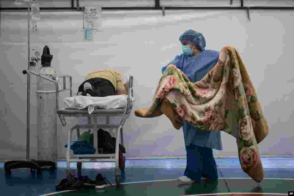 콜롬비아 보고타의 축구장에 설치된 임시 병동에서 간호사가 신종 코로나바이러스 감염 환자에게 덮어줄 담요를 나르고 있다.