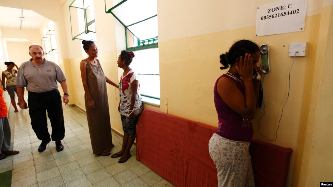 FILE - An Eritrean would-be immigrant talks on the phone at the Lyster barracks detention center for immigrants in Hal Far, outside Valletta, Malta.