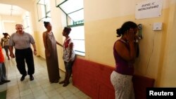 FILE - An Eritrean would-be immigrant talks on the phone at the Lyster barracks detention center for immigrants in Hal Far, outside Valletta, Malta.