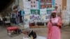 A woman speaks on her mobile phone as she stands in front of campaign posters of the Samm Sa Kaddu (Keep Its Word) coalition for the upcoming early legislative election in Dakar, Senegal, Nov. 11, 2024.