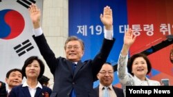 문재인 한국 대통령과 영부인 김정숙 여사가 10일 오전 서울 여의도 국회 로텐더홀에서 제19대 대통령 취임식을 마치고 국회를 떠나며 환영하는 시민들에게 손을 들어 인사하고 있다.