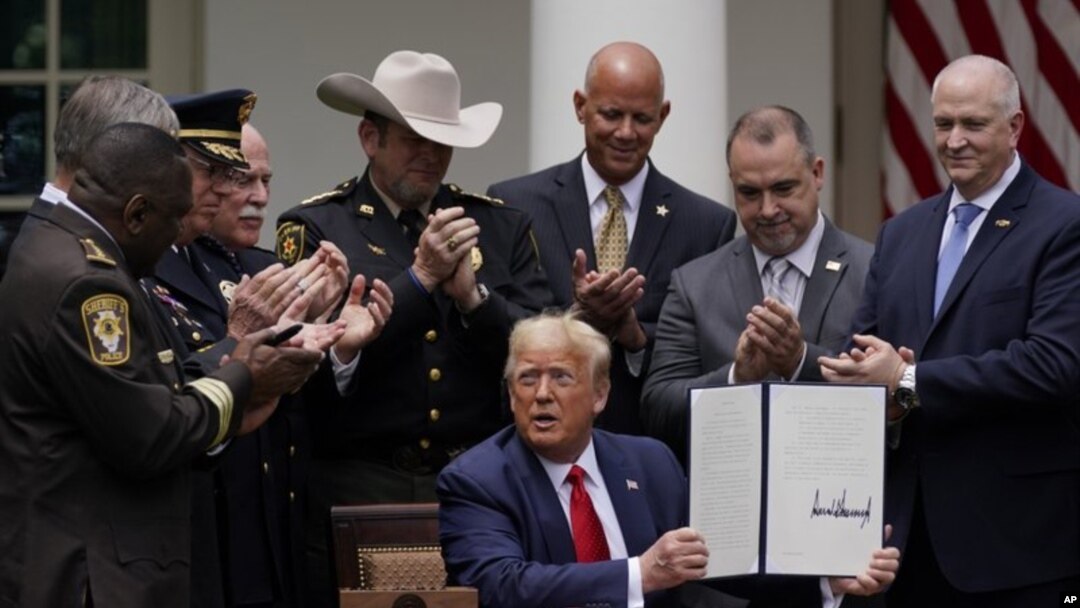Para pejabat penegak hukum bertepuk tangan setelah Presiden Donald Trump menandatangani instruksi presiden tentang reformasi polisi, Rose Garden, Gedung Putih, Selasa, 16 Juni 2020. (Foto: AP Photo/Evan Vucci)