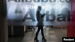 Employee seen behind glass door of Alibaba's company headquarters on the outskirts of Hangzhou, Zhejiang province, April 23, 2014.