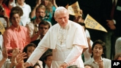 In a Sept. 15, 1987 file photo, Pope John Paul II walks among young people at the Universal Amphitheatre in Los Angeles, California. 