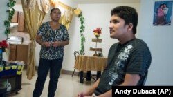 Ajuda Thapa, left, stands near her son, Jay Thapa, in their home in Burlington, Vt. Ajuda Thapa, 45, a former refugee from Bhutan, participates in a program for torture survivors at the University of Vermont 