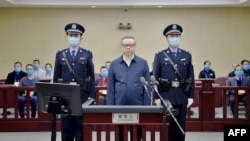 This handout photo taken on August 11, 2020 and released by the Second Intermediate People’s Court of Tianjin, shows Lai Xiaomin (C), former chairman of China Huarong Asset Management Co., standing during his trial at the Second Intermediate People…