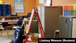 Dua anak sedang menggambar di tempat penitipan anak untuk para petugas kesehatan dan petugas gawat darurat di SD Midway, di tengah pandemi COVID-19 di Des Moines, Washington, 26 Maret 2020. (Foto: Reuters)