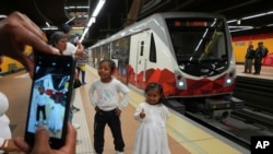 Niños posan para una fotografía en una plataforma del Metro de Quito, en Quito, Ecuador, el 1 de diciembre de 2023.