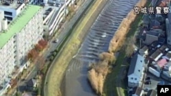 In this image made off a video released by Miyagi Prefectural Police, water rush up Sunaoshi river in Tagajo, Miyagi prefecture, Nov. 22, 2016. A powerful earthquake off the northeast Japanese shore Tuesday sent residents fleeing to higher ground.