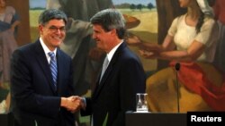 Argentine Finance Minister Alfonso Prat-Gay and U.S. Treasury Secretary Jack Lew shake hands after giving a joint statement in Buenos Aires, Argentina, Sept. 26, 2016. 