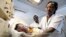 FILE - A nurse weighs a baby at the Maitama district hospital in Nigeria's capital of Abuja, May 22, 2011.   