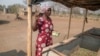 Mari Choumumba stands next to a production tank of maggots at her home in Chiredzi, Zimbabwe, on Sept. 18, 2024.