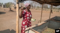 Mari Choumumba stands next to a production tank of maggots at her home in Chiredzi, Zimbabwe, on Sept. 18, 2024.