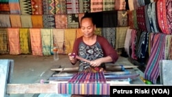 Seorang perempuan Sasak di Lombok, sedang menenun, kegiatan yang dianggap pekerjaan domestik perempuan. (Foto: Petrus Riski/VOA).jpg