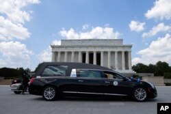 El coche fúnebre que llevó el ataúd del fallecido legislador de Georgia, John Lewis, al Capitolio en Washington, para una capilla ardiente, pasa por delante del Monumento a Lincoln, el lunes 27 de julio de 2020.