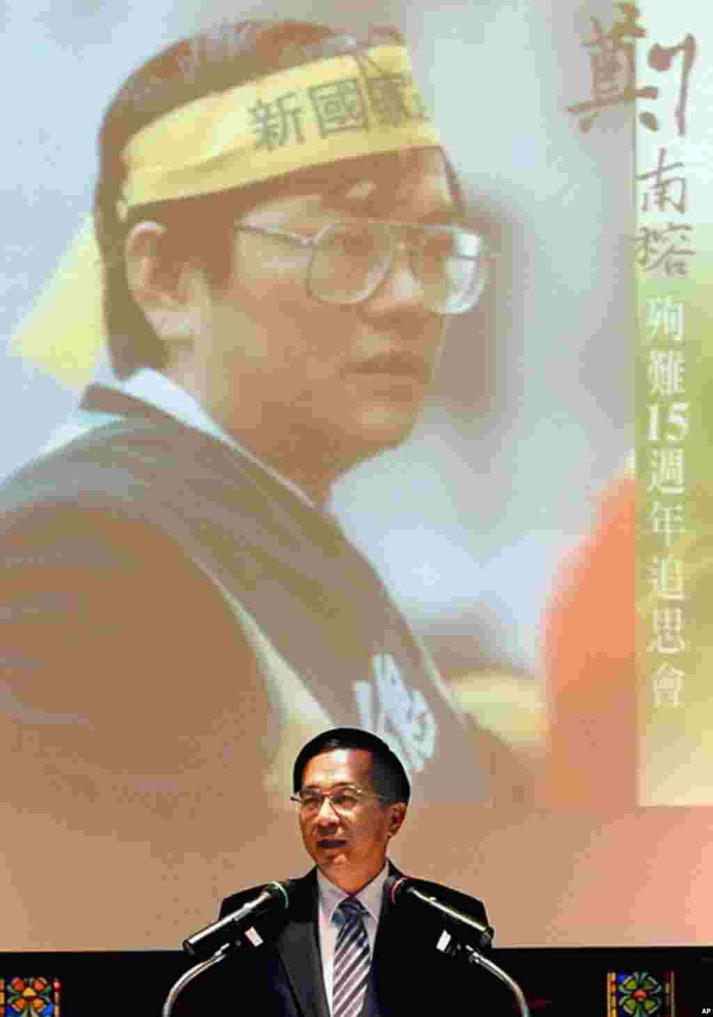 2004年4月7号，台湾总统陈水扁访到北郊外的郑南榕墓地之后发表讲话，纪念这位台湾独立活动人士去世15周年。1989年，郑南榕为了抗议当时的执政党国民党控制言论自由而自焚身亡。陈水扁身后的照片为郑南榕。 (KMT), April 07, 2004. (AFP)