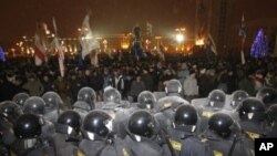 Riot police block demonstrators trying to storm the government building in the Belarusian capital, Minsk, 19 Dec 2010