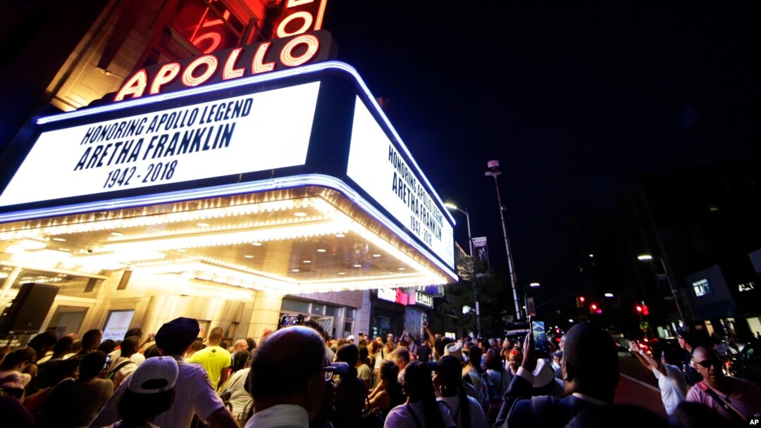 People gather at a makeshift memorial at the nameplate for singer Aretha Franklin outside the Apollo Theater, Aug. 16, 2018, in New York. Franklin died Thursday in her home in Detroit at age 76 from pancreatic cancer.