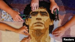 Sebuah mosaik yang menampilkan potret dari pesepakbola Diego Maradona dibuat oleh sekelompok seniman di Buenos Aires, Argentina, pada 24 Februari 2021. (Foto: Reuters/Agustin Marcarian)