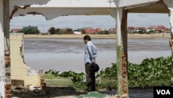 Seorang warga mengamati reruntuhan rumah di Danau Boeung Kak di Phnom Penh (16/8). Kamboja mendapat tekanan dari Bank Dunia untuk membangun pemukiman bagi penduduknya yang kehilangan tempat tinggal.