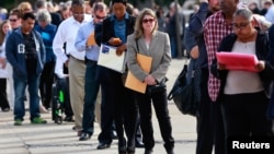 FILE - People wait in line to enter the Nassau County Mega Job Fair at Nassau Veterans Memorial Coliseum in Uniondale, N.Y., Oct. 7, 2014. 